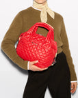 MZ Wallace Small Sutton Deluxe Bright Cherry Hobo & Shoulder worn by model wearing olive green sweater and black trousers