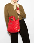 MZ Wallace Small Sutton Deluxe Bright Cherry Hobo & Shoulder worn by model wearing olive green sweater and black trousers
