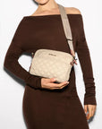 MZ Wallace Small Metro Camera Bag Buff Crossbody worn by model wearing brown off the shoulder dress in front of white background