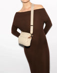 MZ Wallace Small Metro Camera Bag Buff Crossbody worn by model wearing brown off the shoulder dress in front of white background