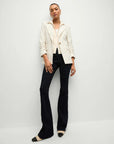 model wearing the Veronica Beard uptown cashmere dickey in ivory with black trousers a white pinstripe blazer and tan and black boots on a white background