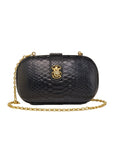 Black textured handbag with gold chain and clasp on a light gray background