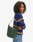 side view of a black model wearing a blue striped sweater and jeans wearing the Clare v Petite Jeanne Loden Suede on a white background