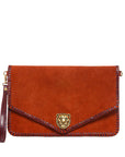 Brown suede clutch bag with lion head emblem on a light beige background
