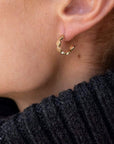 Margaux 1/2" Hoops Gold Jewelry - Earrings from Jennifer Zeuner on a model wearing a turtleneck