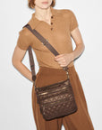 another angle of a girl wearing a brown knit top and brown trousers wearing the mz Wallace Downtown Crosby Crossbody Walnut on a white background