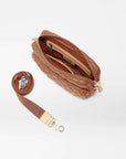 top view of the mz wallace Small Metro Tote Camera Bag Terracotta on a grey background with the strap laid out