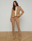 full front view of a brunette model wearing the l'agency Brooke double breasted crop blazer in latte/gold with tan pants and a brown belt