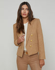 front upper half view of a brunette model wearing the l'agency Brooke double breasted crop blazer in latte/gold with tan pants and a brown belt