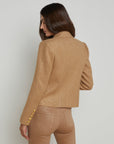 upper half back view of a brunette model wearing the l'agency Brooke double breasted crop blazer in latte/gold with tan pants and a brown belt