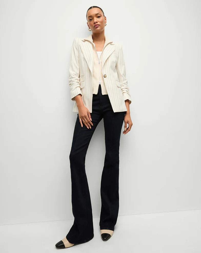 model wearing the Veronica Beard uptown cashmere dickey in ivory with black trousers a white pinstripe blazer and tan and black boots on a white background