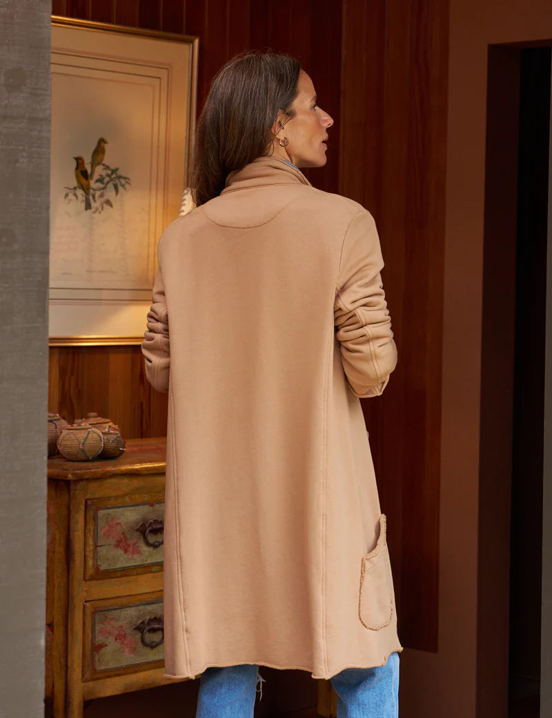 back of brunette model wearing the Frank & Eileen Sweatshirt Trench Coat Camel and jeans while standing in a wood paneled house