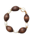 Bracelet with wooden beads and pearls on a light gray background