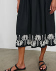 lower half view of brunette girl wearing rails baja dress in black ivory palm trees with black sandals