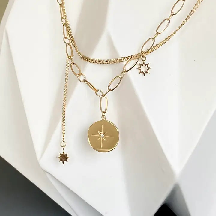 close up of the pendants on the Ma Cocotte Cosmos Necklace on a white background