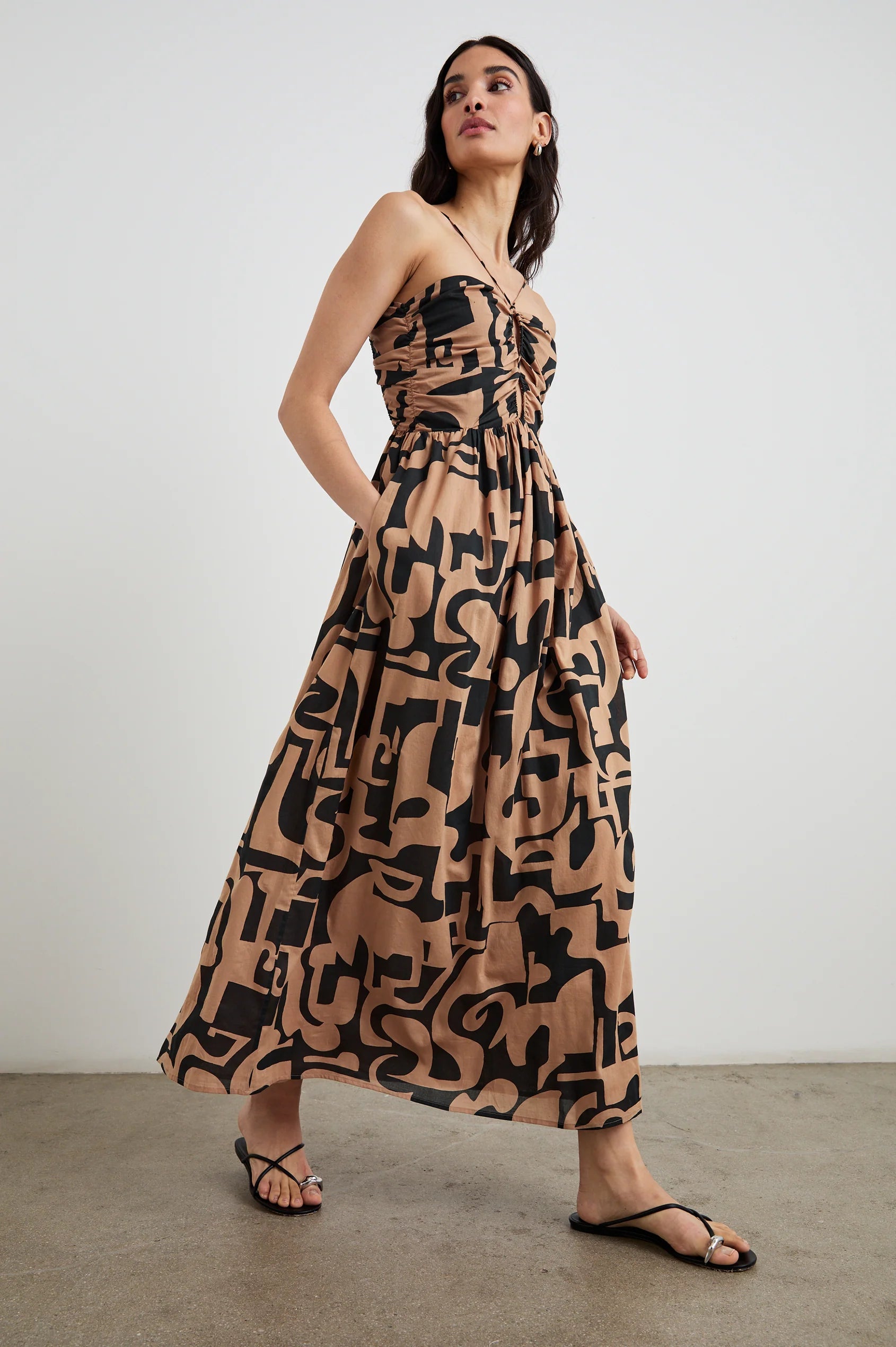 side view of brunette girl wearing rails silvia dress in santorini sand and sandals with her hand in the pocket