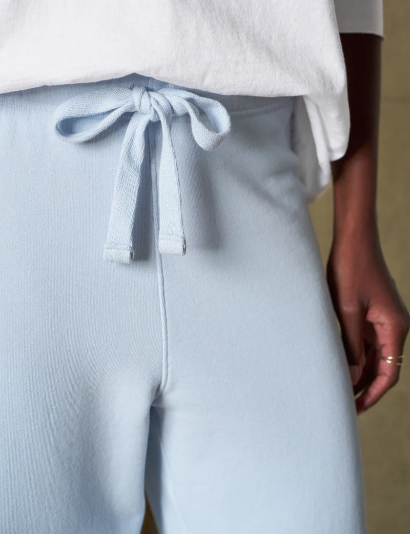 close up of the waist band and tie of the frank & eileen Catherine Favorite Sweatpant Ice on a black model with a white top and white sneakers in from of the boucle bench and white wall