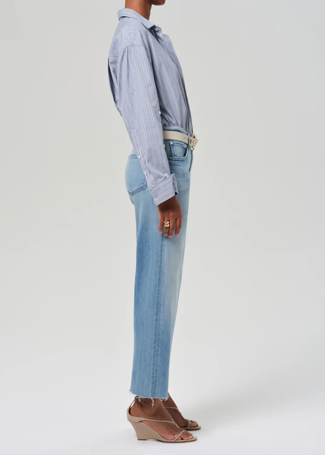 full right side view of model wearing the citizens of humanity Palma Straight Lisbon with a white belt, tan sandals, and a blue striped button down on a white background