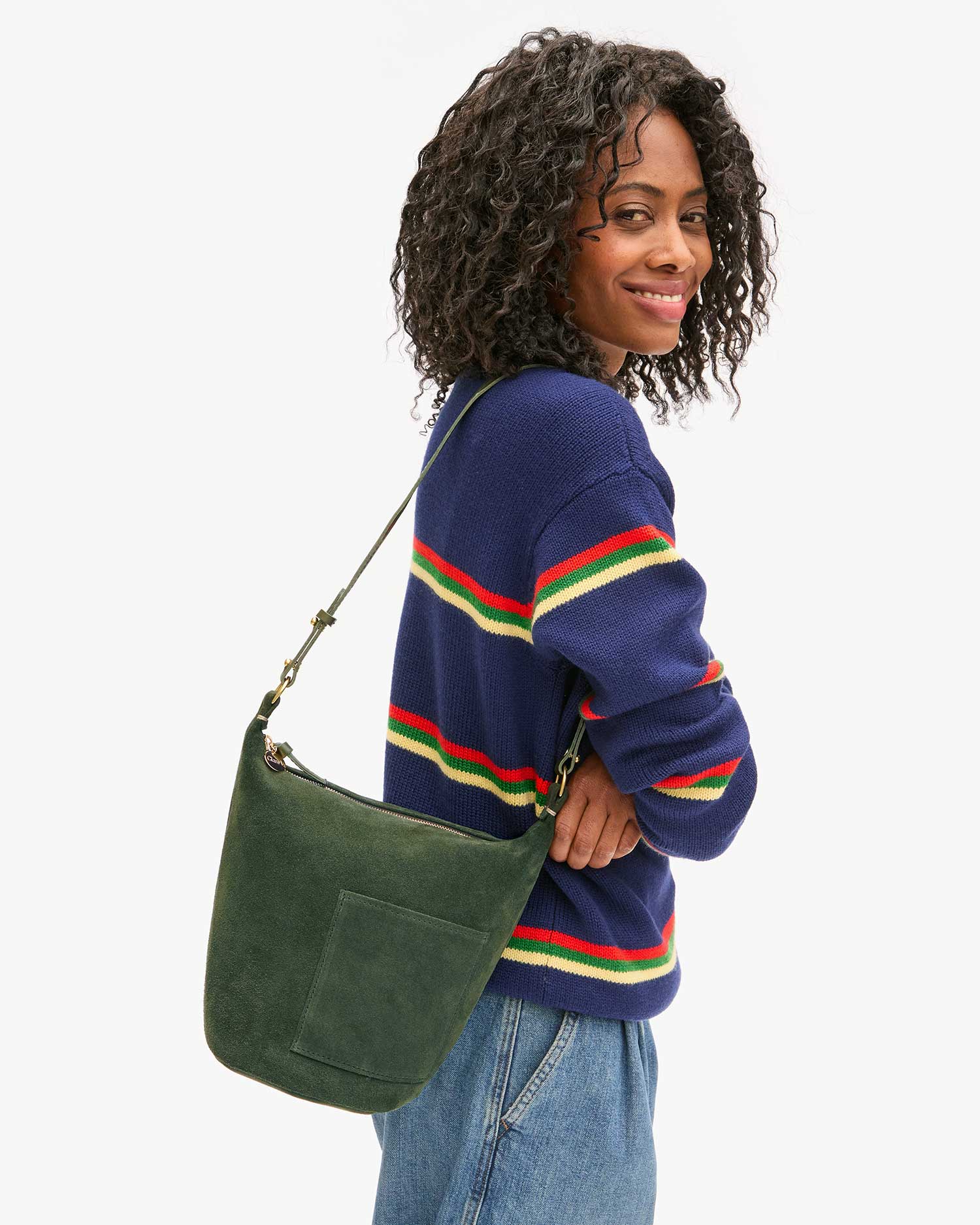 side view of a black model wearing a blue striped sweater and jeans wearing  the Clare v Petite Jeanne Loden Suede on a white background