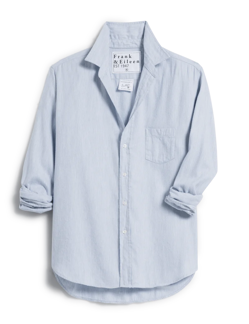 cutout front view of  frank & eileen Eileen Relaxed Button Up Gray Blue with jeans in front of a console table and art