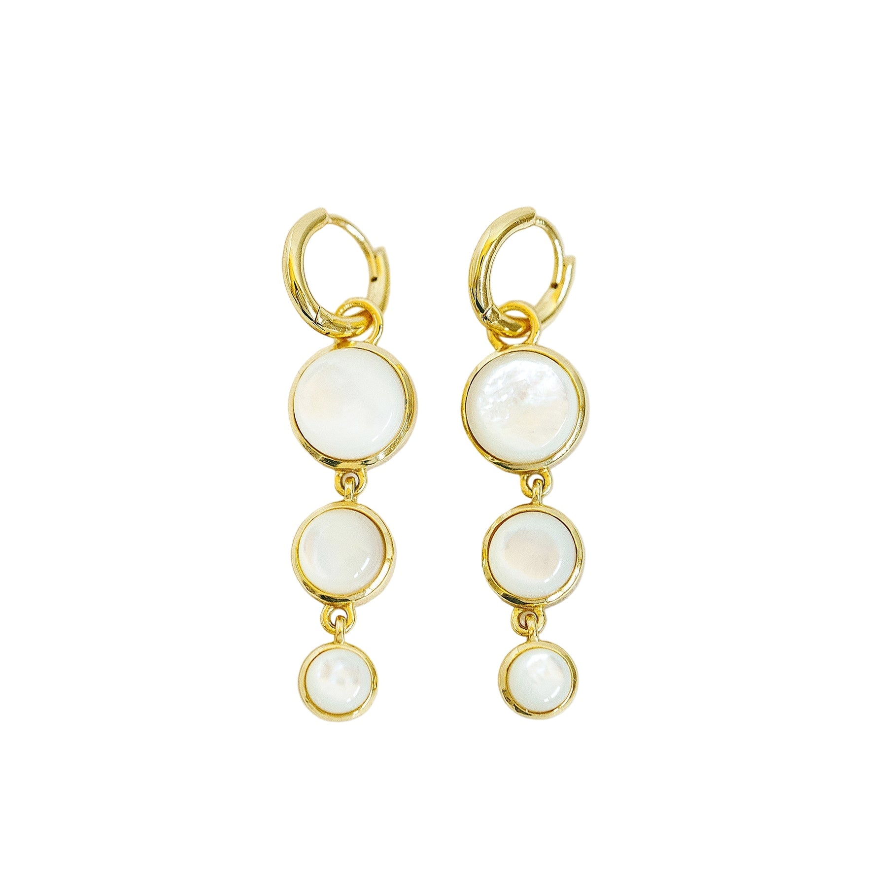 Gold earrings with multiple circular elements on a light background