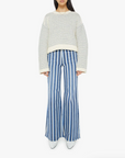 full front view of brunette girl wearing mother bell sleeve jumper roll in did you make that on a white background with striped blue pants