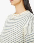 close up view of chest of the sweater on a brunette girl wearing mother bell sleeve jumper roll in did you make that on a white background with striped blue pants