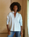 front top half view of a black model wearing the frank & eileen Patrick Popover Henley Triple Fleece Ice and jeans in front of a beige background 