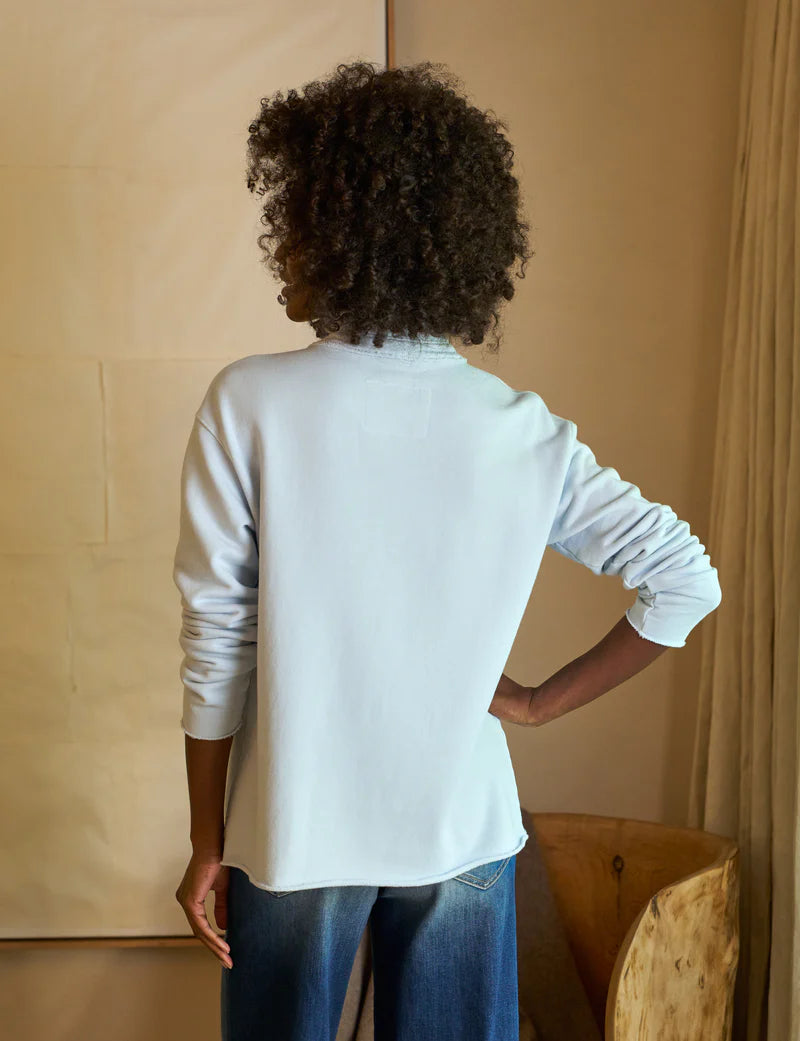 back top half view of a black model wearing the frank & eileen Patrick Popover Henley Triple Fleece Ice and jeans in front of a beige background