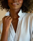 close up view of the collar of a black model wearing the frank & eileen Patrick Popover Henley Triple Fleece Ice in front of a beige background