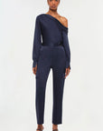 full front view of model on a white background wearing the simkhai Carolina utility pant in midnight with a matching blue blouse and black strappy heels