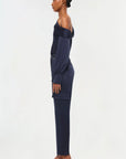 full side view of model on a white background wearing the simkhai Carolina utility pant in midnight with matching blouse and black strappy heels