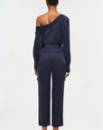 full back view of model on a white background wearing the simkhai Carolina utility pant in midnight with matching blouse and black strappy heels