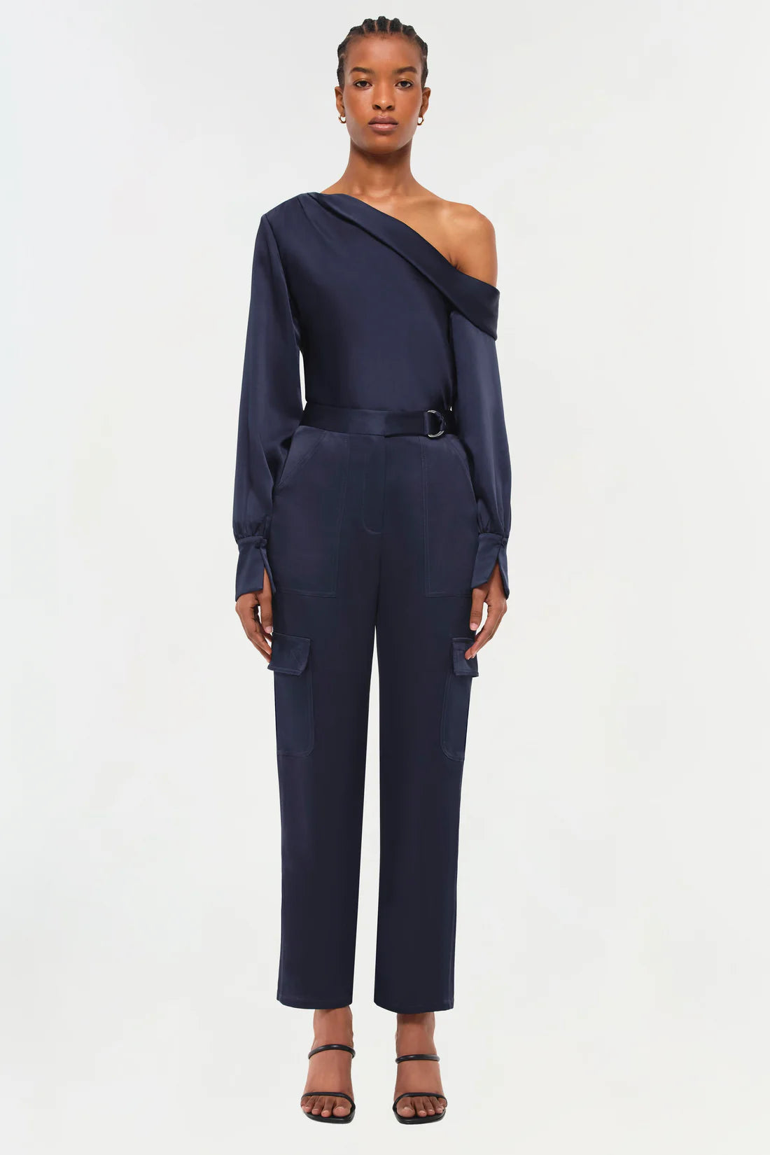 full front view of model on a white background wearing the simkhai Carolina utility pant in midnight and a matching blouse and strappy black heels